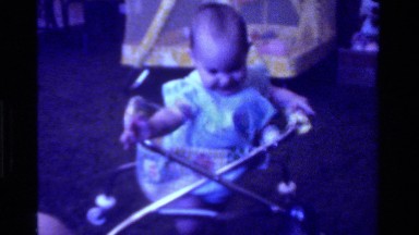 1975: baby walking with walker toy CALIFORNIA