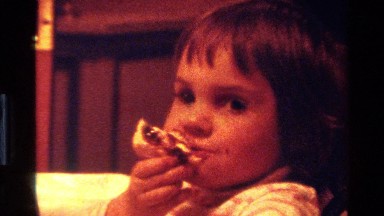 1977: a small girl kid eating some fruits with her right hand happily CALIFORNIA