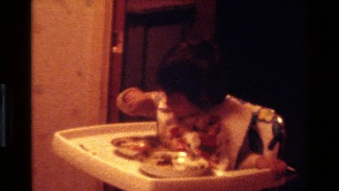 1977: a small girl busy in eating food on a dining table CALIFORNIA