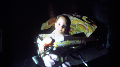 1977: video zooms in on a baby face. CALIFORNIA