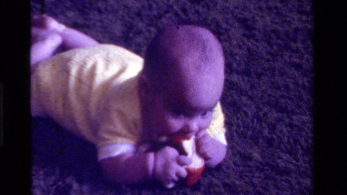 1975: sweet little baby eating apple in funny mood