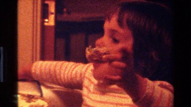 1977: a small baby girl busy in eating some cakes CALIFORNIA