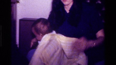 1977: a mother putting a jacket on her baby CALIFORNIA