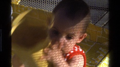 1977: baby in playpen playing with plastic container CALIFORNIA