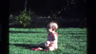 1977: a baby sitting outside on the grass CALIFORNIA