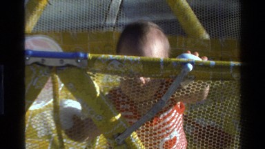 1977: baby standing up in a playpen CALIFORNIA