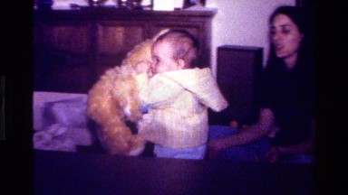 1977: a small baby playing with doll and mother in a bedroom CALIFORNIA
