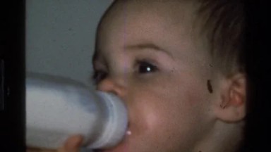 1977: A Baby Drinking a Bottle of Milk Next to Grandma California