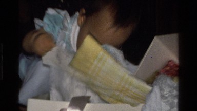 1977: a baby opens a christmas gift-it's a blanket CALIFORNIA