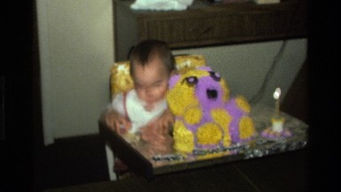 1977: a small baby happily eats off his finger in his highchair CALIFORNIA
