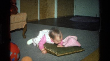 1977: baby laying on pillow on a living room floor CALIFORNIA