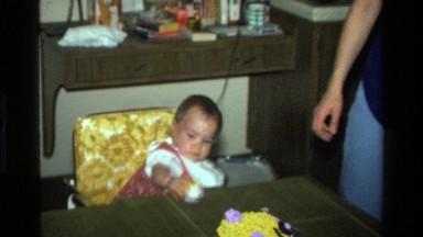 1977: a baby girl reaching for a toy with icing on her face CALIFORNIA