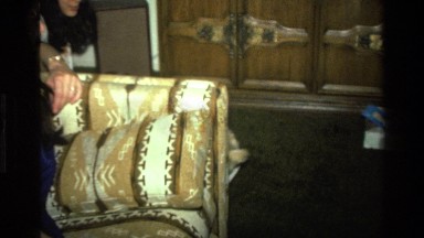 1977: pushing baby around in a box in the living room with stuffed toys.