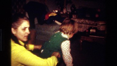 1977: mommy getting her baby dressed CALIFORNIA