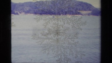 1977: a man is moving in speed boat in a river beside a large mountain LAKE