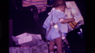 1977: baby playing with used wrapping paper CALIFORNIA