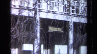 1969: A Woman in Blue Dress Walking in Front of White Building California