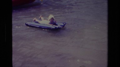 1978: a toddler on blue plastic mat floating in the lake. CANYON LAKE CALIFORNIA