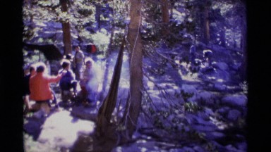 1975: a group of friends sitting around a campfire in the woods MINARET