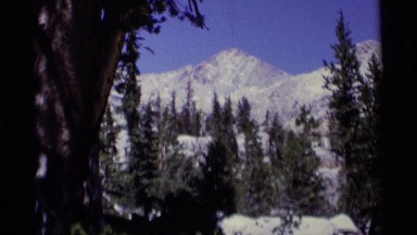 1975: a beautiful snow covered mountain and water cascading through some rocks