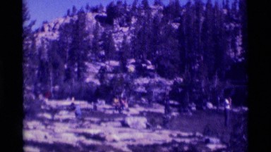 1975: backpackers camping in the wilderness surrounded by granite outcrops