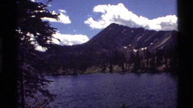 1972: a tranquil view of a river beneath a mountain HOLLAND LAKE MONTANA