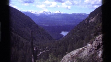 1972: view across two hills of a valley and distant mountains with their snowy