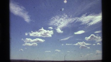 1972: a large ground area with water around and blue sky at the top HOLLAND LAKE