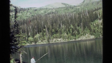 1972: a man fishing in a river next to a large forest HOLLAND LAKE MONTANA