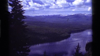 1972: panorama of a mountain valley with trees, lake and jagged peaks HOLLAND