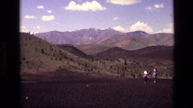 1972: two people walking from the awesome mountain behind them. IDAHO