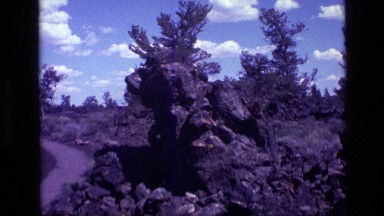 1972: a large craggy gray rock formation sits in a field IDAHO