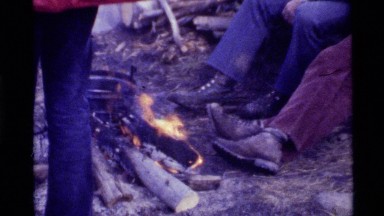 1972: Men Camping, Sitting by Fire on Log, Standing, and Sawing Wood Holland