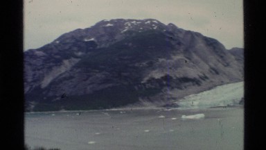 1977: camera pans from right to left across a view that includes mountains