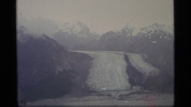 1977: snow-capped mountains with a frozen waterfall on a foggy day GLACIER BAY