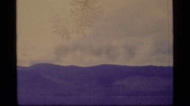 1977: clear cut in forest and boat moving down a river ALASKA