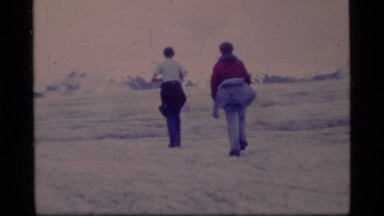 1977: a lady hikes with a walking stick over a vast, flat expanse GLACIER BAY