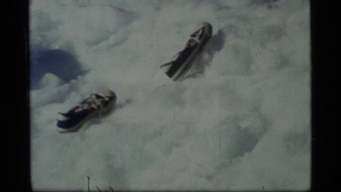 1977: pair of black sneakers with white laces are aligned one behind the other