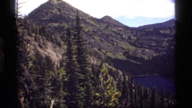 1977: photo from a ridge looking down into a beautiful valley with a lake