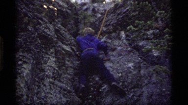 1977: boy rock climbing with rope tied around waist SAPPHIRE LAKE MONTANA