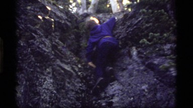 1977: small boy climbing rock hill nearing the summit SAPPHIRE LAKE MONTANA