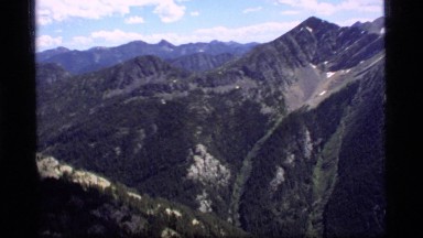 1977: lots of trees grow all over the sides of a large mountain SAPPHIRE LAKE