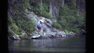 1977: a man fishing on the rocks on the bank of a river SAPPHIRE LAKE MONTANA