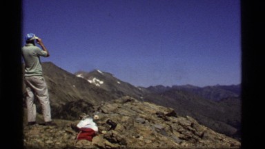 1977: a hiker surveys a valley surrounded by mountains from a ridge