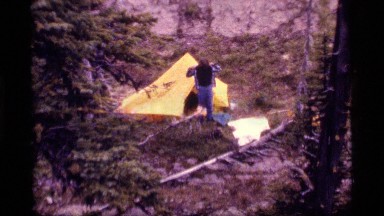 1977: man camping steps out of tent to get dressed. SAPPHIRE LAKE MONTANA