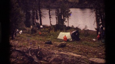 1977: a man pitches his tent at a campsite in the woods SAPPHIRE LAKE MONTANA