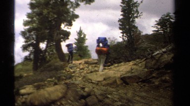 1978: three backpackers walking side slope across scree LAKE TAHOE CALIFORNIA