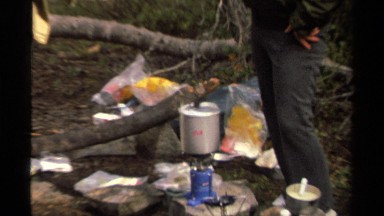 1978: a man serves another man a meal in a cup at a campsite LAKE TAHOE