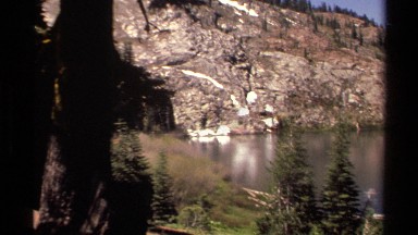 1978: a panoramic view of a lake that is in the middle of a large mountain