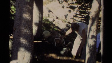1978: a man getting some stuff on the ground and trying to knot a bait